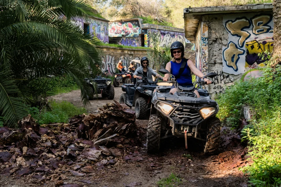 Three Lx4 quads riding through a graffiti-walled trail in Costa da Caparica
