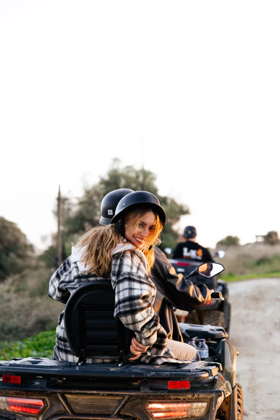 Rider glancing back from her quad in soft golden light at Lx4 Tours