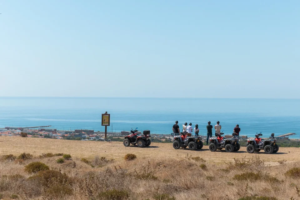 Group of quads parked at a coastal viewpoint overlooking the ocean at Costa da Caparica