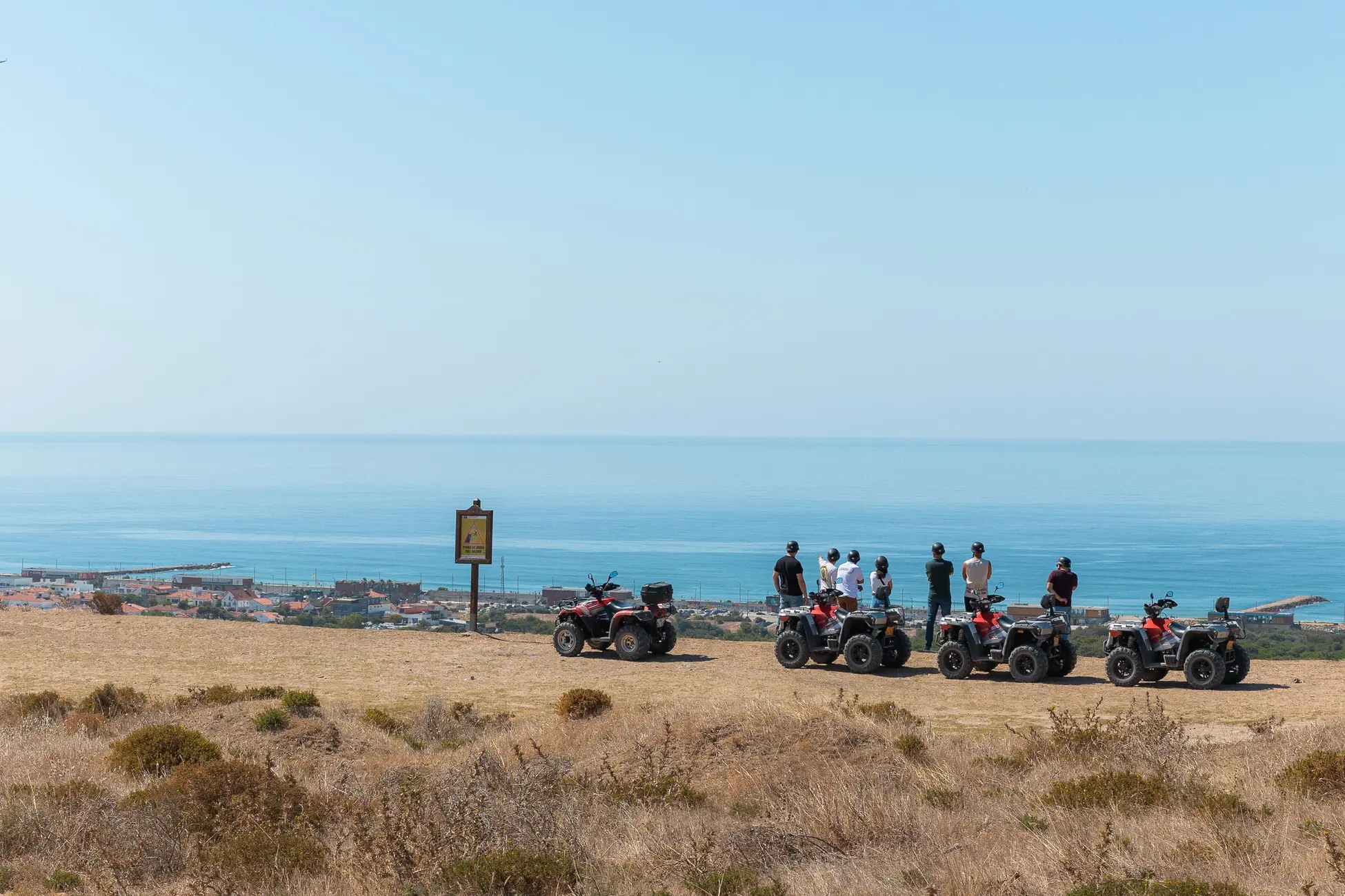 Group of quads parked at a coastal viewpoint overlooking the ocean at Costa da Caparica